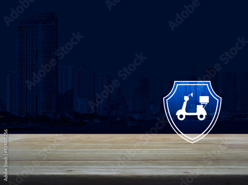 Motorcycle with shield flat icon on wooden table over modern office city tower and skyscraper, Business motorbike insurance concept © grapestock