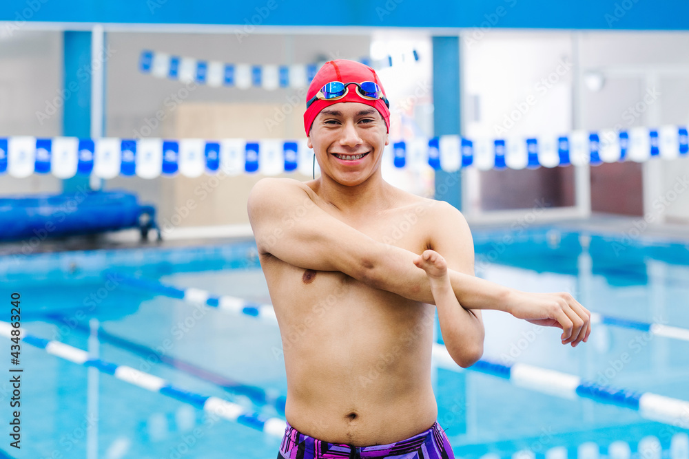 Disabled Swimmer hispanic man Training In Pool with hand hypoplasia in disability concept