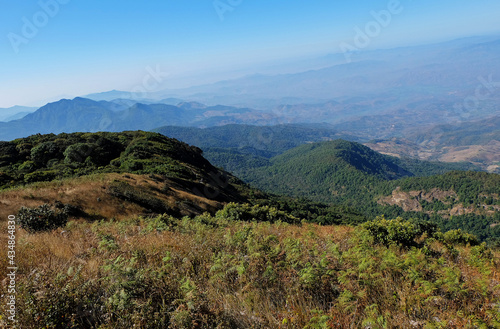 Natural landscape of green mountain range with misty summit hill