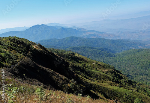 Natural landscape of green mountain range with misty summit hill © chettarin