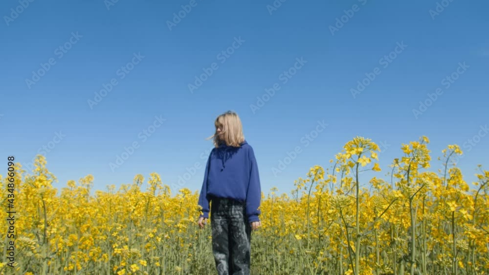 Young woman standing field yellow flowers. Beautiful carefree woman enjoying nature in blooming field Young woman standing field yellow flowers. Beautiful carefree woman enjoying nature in blooming field