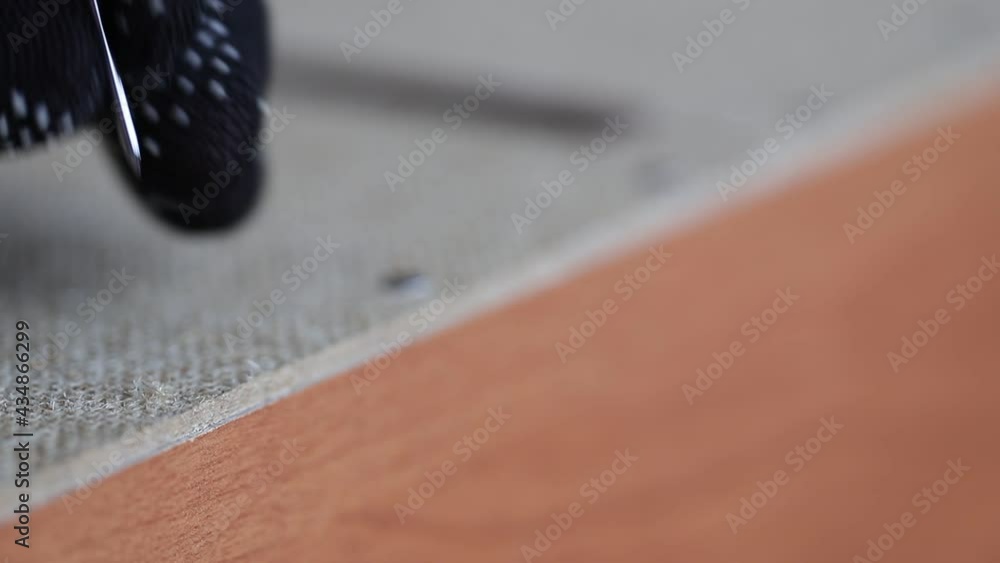 Hammering a wood fiberboard sheet with nails to a wooden base. Fastening wooden elements with nails using a hammer. Manual self-work when assembling furniture. Hammering a wood fiberboard sheet with nails to a wooden base. Fastening wooden elements with nails using a hammer. Manual self-work when assembling furniture.
