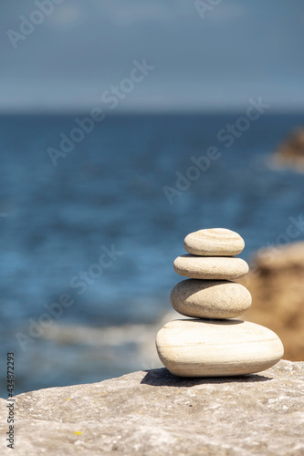 Stack of balance stones by the ocean. Burren  Ireland. Warm sunny day. Selective focus. Pyramid of pebble in nature environment.