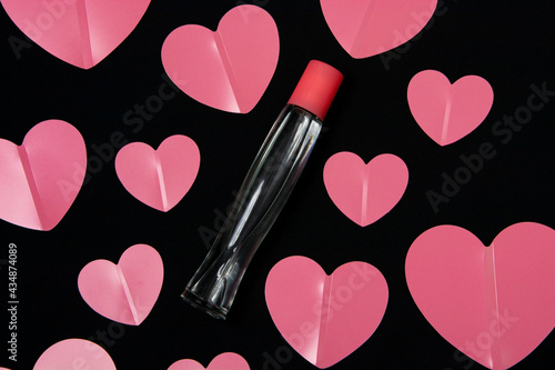 A bottle of perfume and pink hearts.
