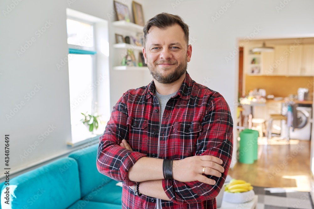Portrait of confident middle aged man, smiling male looking at camera with crossed arms Portrait of confident middle aged man, smiling male looking at camera with crossed arms