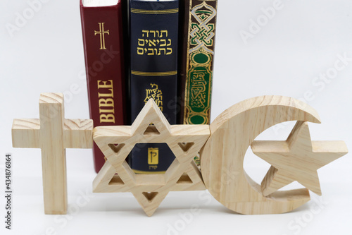 The three monotheistic religions. Christianity, Islam and judaism. Thorah, Quran and Bible with croos, star of David and muslim crescent.  Interreligious or interfaith symbols. France. photo