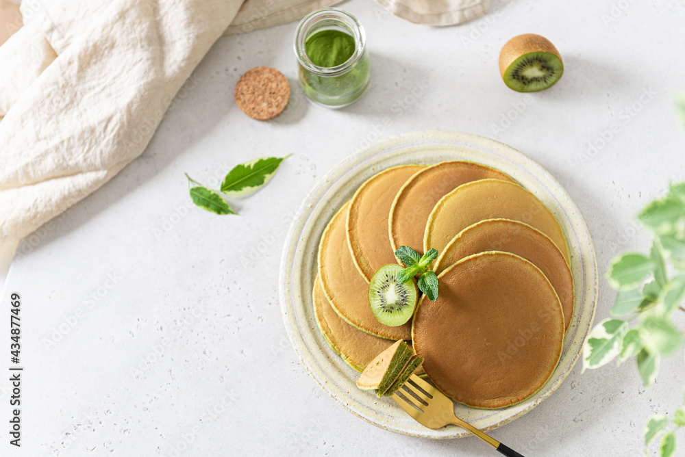 Matcha tea green pancakes. Homemade pancakes with fresh kiwi. healthy breakfast dessert recipe, menu. Top view, copy space Matcha tea green pancakes. Homemade pancakes with fresh kiwi. healthy breakfast dessert recipe, menu. Top view, copy space