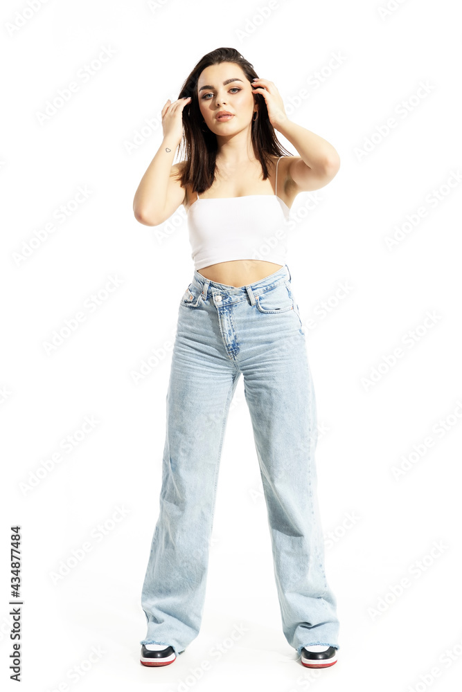 Candid brunette young gen Z woman touching hair posing in summer trendy clothes. Full body length isolated on white background Candid brunette young gen Z woman touching hair posing in summer trendy clothes. Full body length isolated on white background