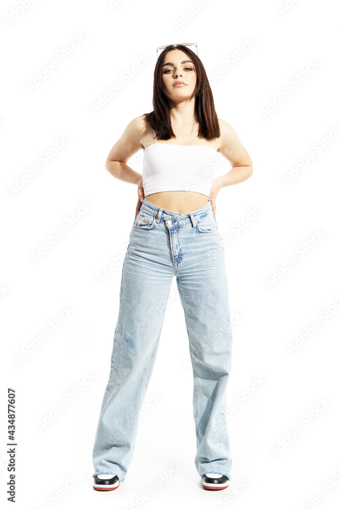Beautiful summer girl in casual clothes posing with hands on hips with cocky attitude. Full body length isolated on white background Beautiful summer girl in casual clothes posing with hands on hips with cocky attitude. Full body length isolated on white background