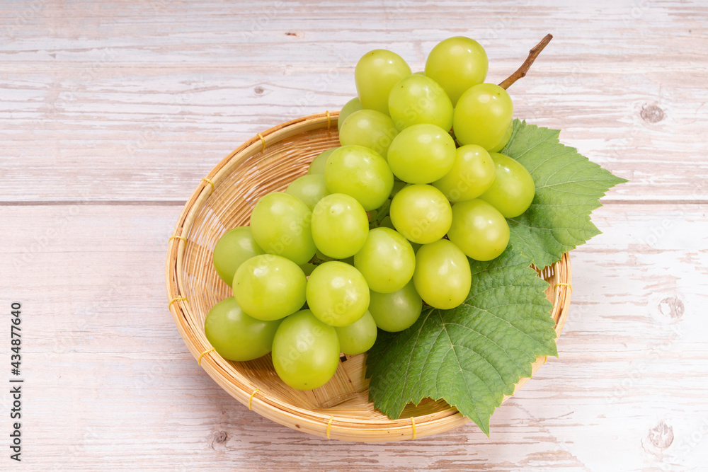 Japanese Shine Muscat Grape in basket on wooden Background, Sweet Green grape on wooden background. Japanese Shine Muscat Grape in basket on wooden Background, Sweet Green grape on wooden background.