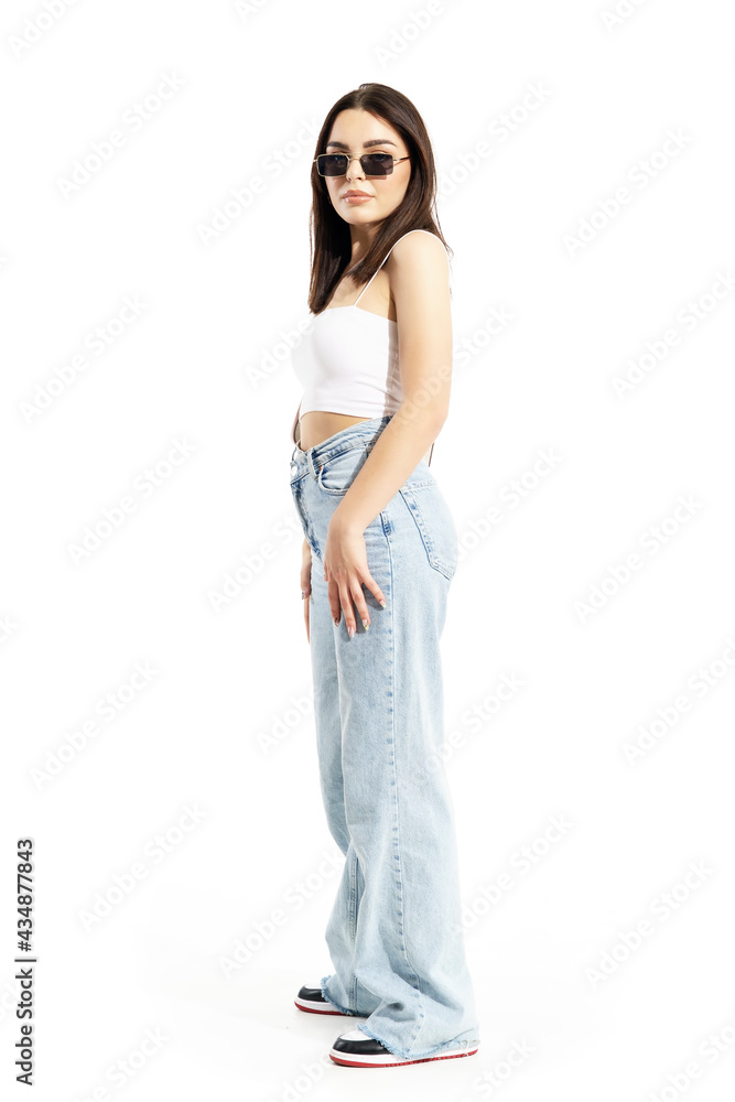 Side view of modern trendy street style woman with sunglasses posing in sunlight. Full body length isolated on white background Side view of modern trendy street style woman with sunglasses posing in sunlight. Full body length isolated on white background
