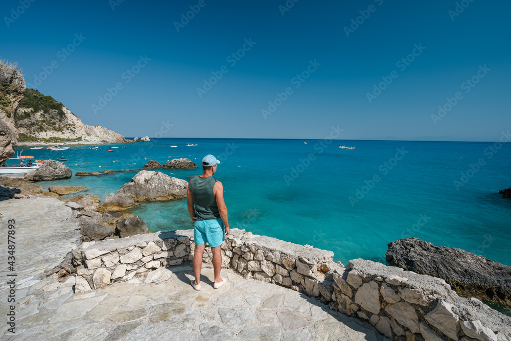 A tourist man enjoy coastline near Agios Nikitas village on Lefkas Ionian Island, Greece
