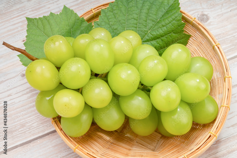 Japanese Shine Muscat Grape in basket on wooden Background, Sweet Green grape on wooden background. Japanese Shine Muscat Grape in basket on wooden Background, Sweet Green grape on wooden background.