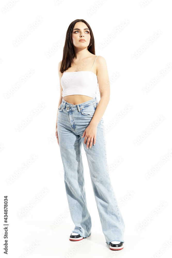 Stunning feminine young woman in summer street style clothes looking up confident. Full body length isolated on white background Stunning feminine young woman in summer street style clothes looking up confident. Full body length isolated on white background