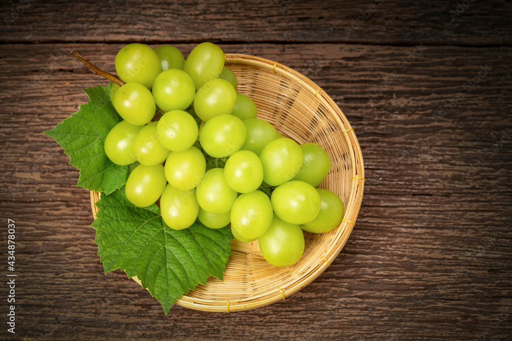 Japanese Shine Muscat Grape in basket on wooden Background, Sweet Green grape on wooden background. Japanese Shine Muscat Grape in basket on wooden Background, Sweet Green grape on wooden background.