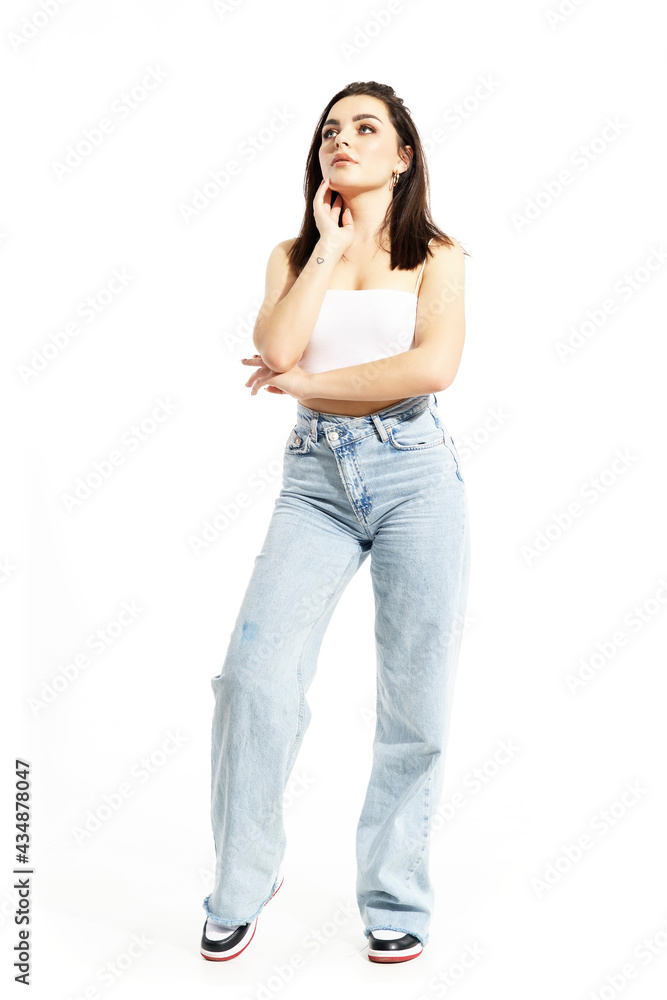 Young gen Z woman in casual summer clothes looking up planing with hand on chin. Full body length isolated on white background Young gen Z woman in casual summer clothes looking up planing with hand on chin. Full body length isolated on white background