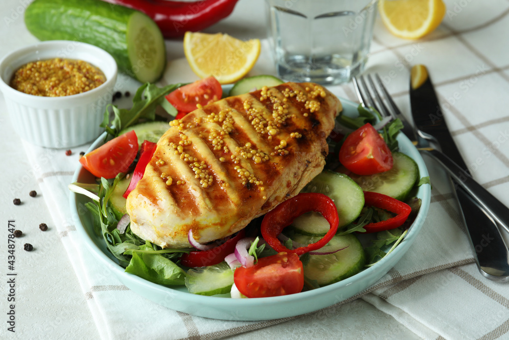 Salad with grilled chicken on white textured table Salad with grilled chicken on white textured table