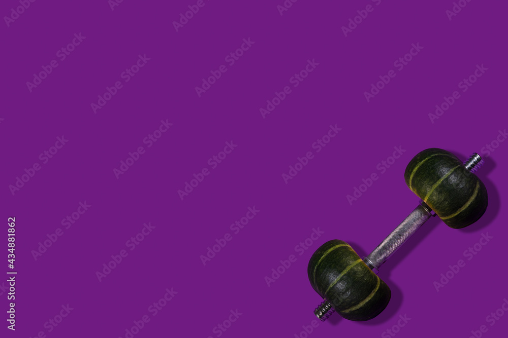 Creative minimal sport concept made of dumbbells with a weight in the form of pumpkins, purple background. Copy space