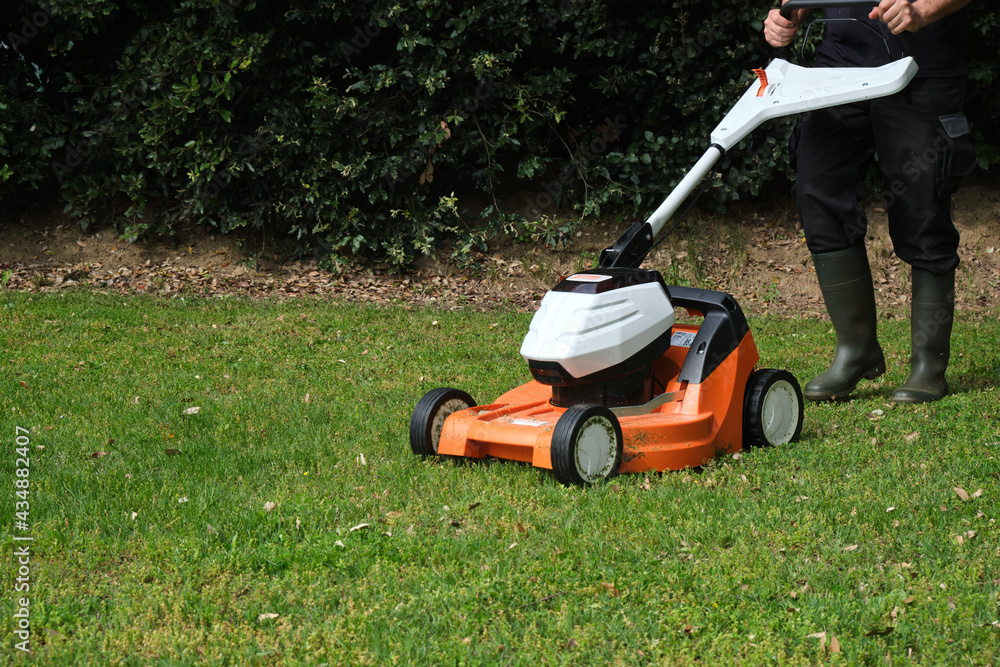 gardener mowing the lawn with a lawn mower gardener mowing the lawn with a lawn mower