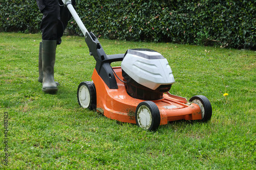 gardener mowing the lawn with a lawn mower