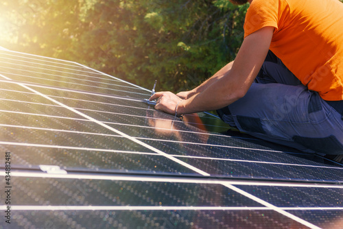 Workers assemble energy system with solar panel for electricity and hot water