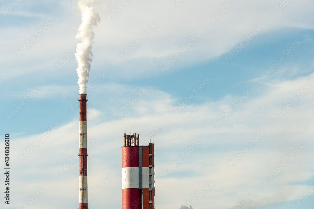 Thick white smoke coming out of a large pipe of an industrial facility or factory. A smoking chimney against a blue sky. Environmental pollution of chemical and pharmaceutical enterprises Thick white smoke coming out of a large pipe of an industrial facility or factory. A smoking chimney against a blue sky. Environmental pollution of chemical and pharmaceutical enterprises