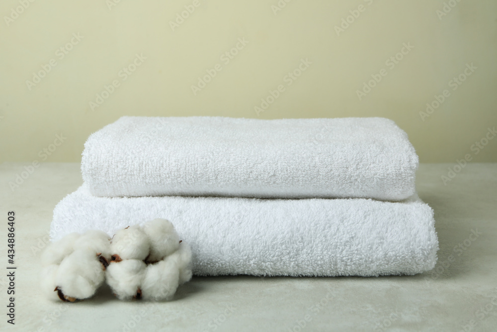 Clean folded towels with cotton on textured table Clean folded towels with cotton on textured table
