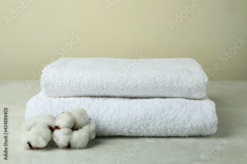 Clean folded towels with cotton on textured table