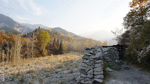 Stone castle, near the walls and inside. Huge stone walls of the fortress. Layer of cement and sand. There are tools for construction. View of the forest, mountains from the fortress. Small window.