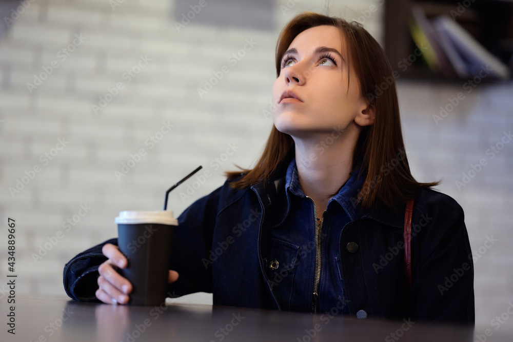 Pensive girl in a cafe with a cup of coffee. Pensive girl in a cafe with a cup of coffee.