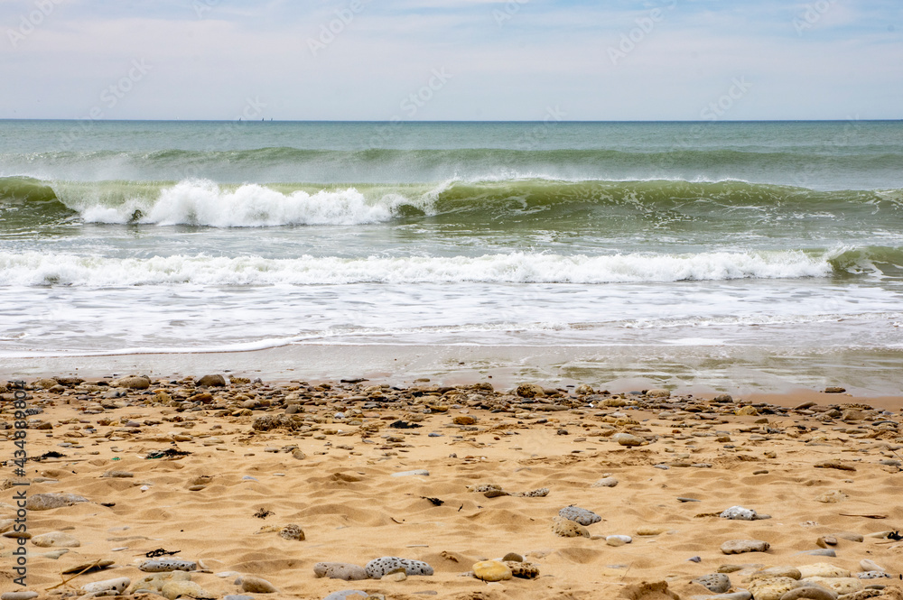Vagues arrivant sur une plage de sable avec l'horizon en fond Vagues arrivant sur une plage de sable avec l'horizon en fond