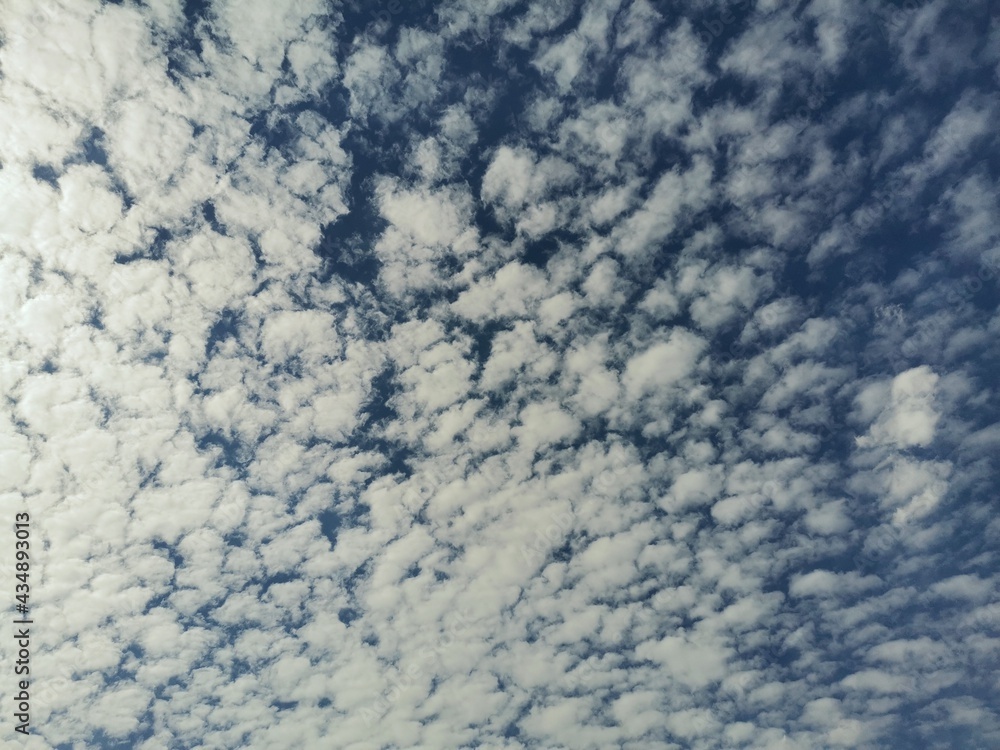 Dark blue sky, patterned clouds. Sky and clouds in the background. Dark blue sky, patterned clouds. Sky and clouds in the background.