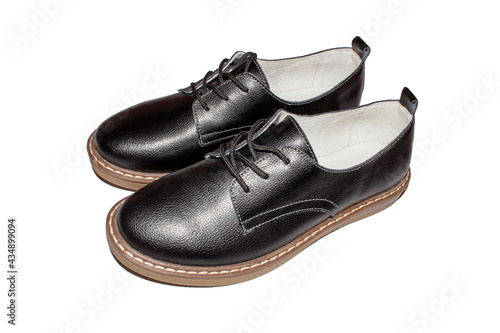 Black leather women's classic shoes with lacing on a white background.Shoes made of black genuine leather with brown soles.