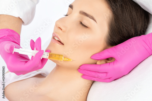 Cosmetologist does prp therapy on the face of a beautiful woman in a beauty salon. Cosmetology concept.