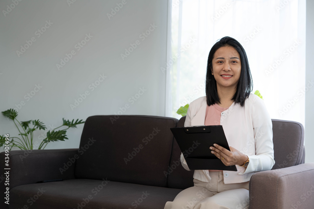 A young Asian businesswoman holds a clipboard to work. Asian woman A young Asian businesswoman holds a clipboard to work. Asian woman