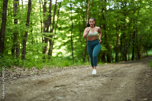 Plus size runner woman in the forest