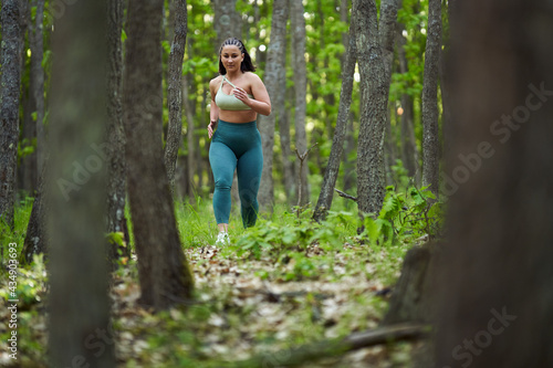 Plus size runner woman in the forest