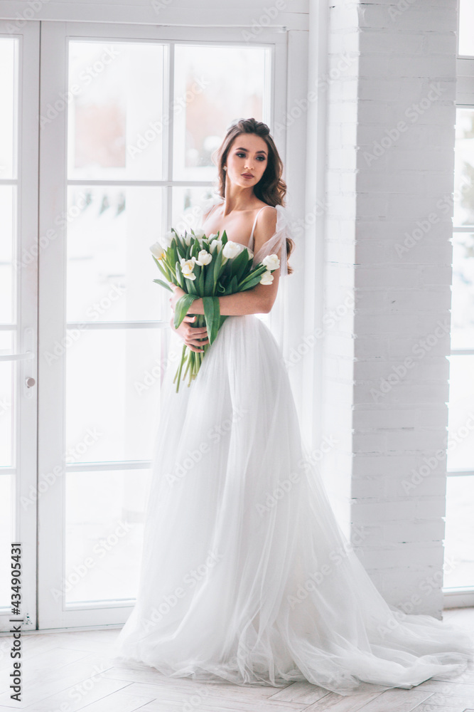 Beautiful brunette woman as bride with wedding bouquet in studio Beautiful brunette woman as bride with wedding bouquet in studio