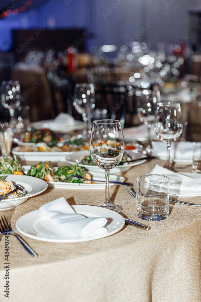 Table setting for a banquet or celebration. Empty wine glasses for spirits, champagne and juice. Set the table. Cloth napkins on a platter. Close-up