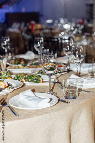 Table setting for a banquet or celebration. Empty wine glasses for spirits  champagne and juice. Set the table. Cloth napkins on a platter. Close-up