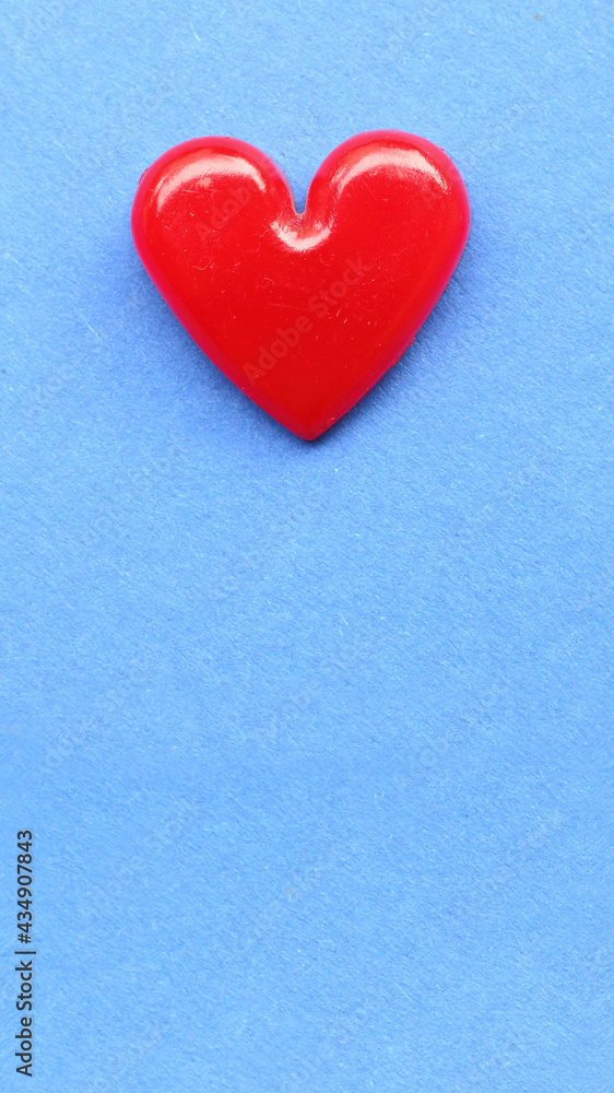 Red heart on blue paper. Background on health care or love theme.