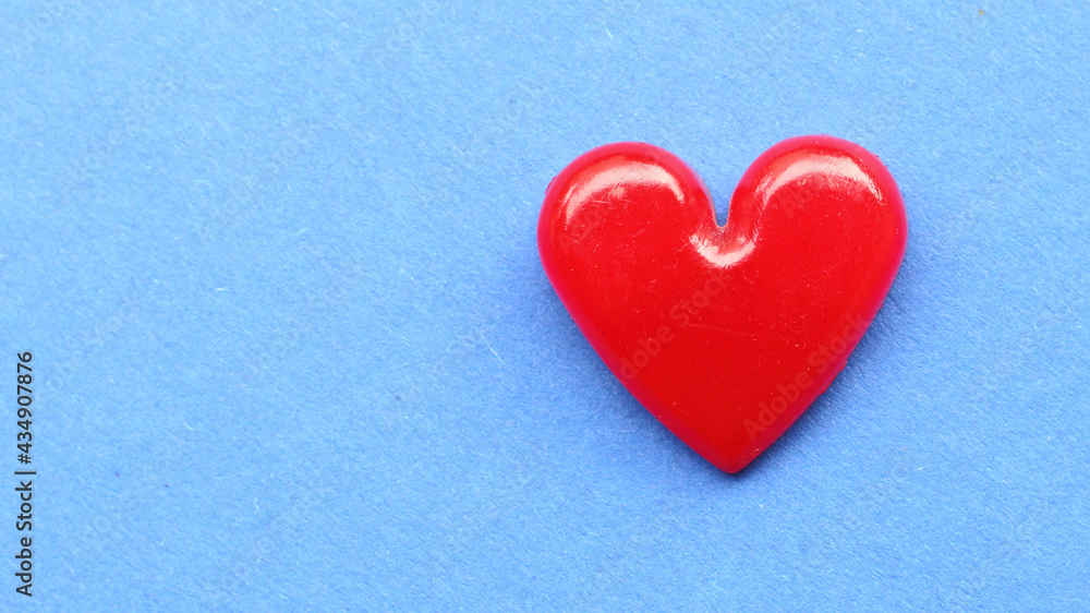 Red heart on blue paper. Background on health care or love theme.