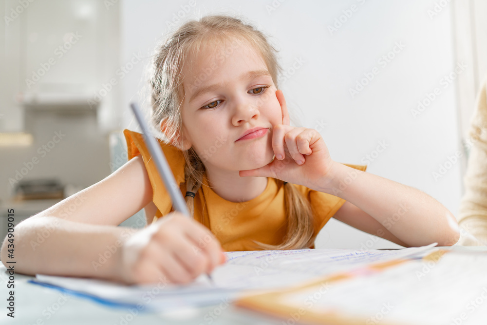A thoughtful schoolgirl does her homework. A thoughtful schoolgirl does her homework.
