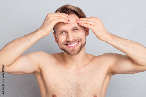 Photo of masculine blond hairdo guy touch face without clothes isolated on grey color background