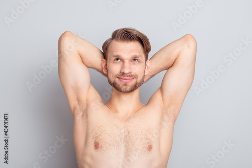 Photo of macho blond hairdo guy look empty space without clothes isolated on grey color background