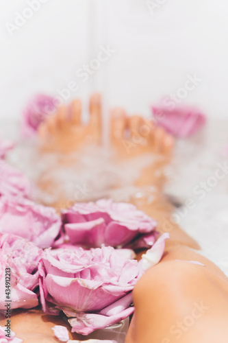 Point of view Female feet bathing in rose flowers