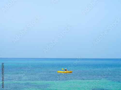 Fototapeta Naklejka Na Ścianę i Meble -  Asian tourist on yellow Kayak boat in tropical island blue sea bright sun in summer. Koh Kood - Thailand