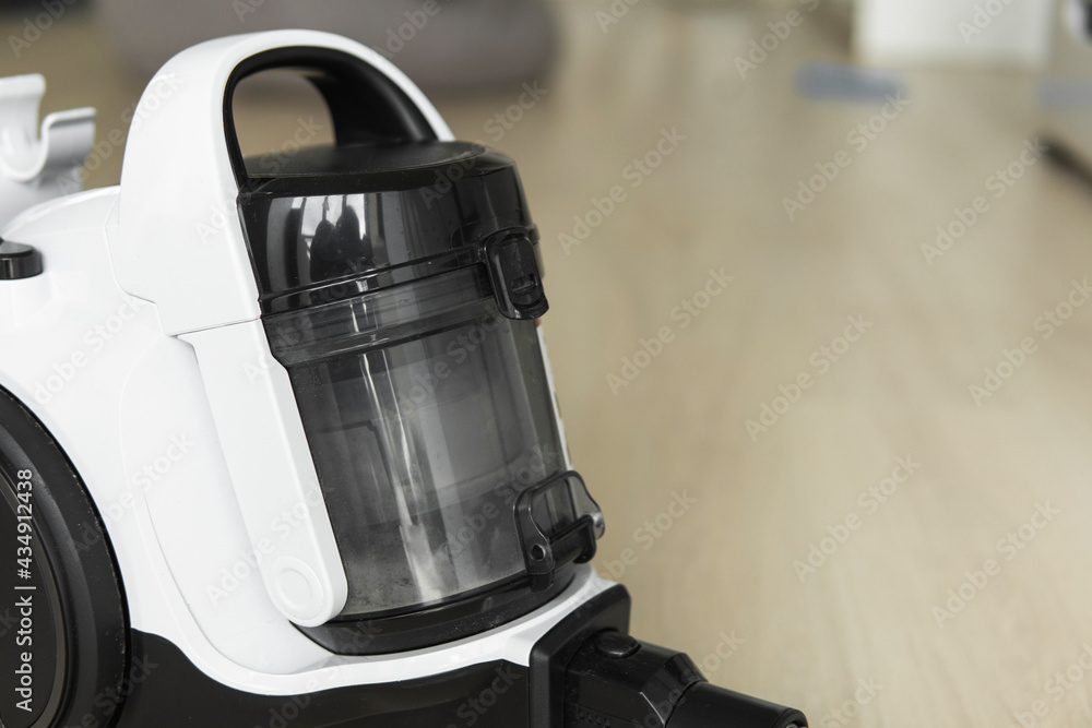 Bagless cyclone vacuum cleaner on a laminate. Electrical apparatus that by means of suction collects dust and small particles from floors and other surfaces. Bagless cyclone vacuum cleaner on a laminate. Electrical apparatus that by means of suction collects dust and small particles from floors and other surfaces.