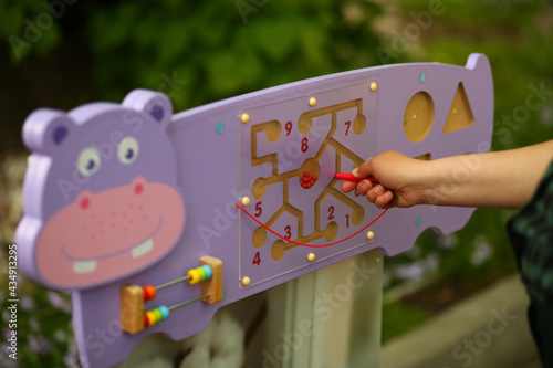 Closeup of a hand playing with a busyboard in the nursery  photo