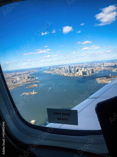 Vertical shot of a cityscape and the sea from an airplane window photo